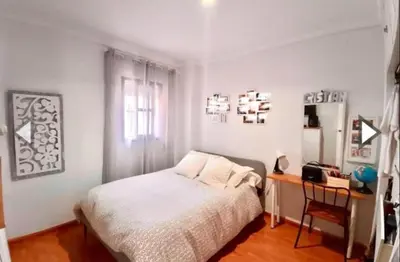 a white bedroom with a bed and a desk at Alojamiento céntrico y confortable in Sanlúcar de Barrameda