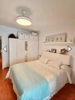 a bedroom with a large white bed with a light at Alojamiento céntrico y confortable in Sanlúcar de Barrameda