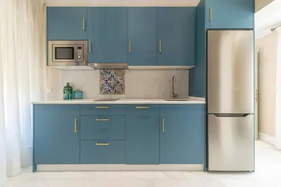a kitchen with blue cabinets and a stainless steel refrigerator at La Casa de la Plaza del Arroyo - Traditional Luxury in Jerez in Jerez de la Frontera