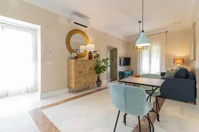 a living room with a table and a couch at La Casa de la Plaza del Arroyo - Traditional Luxury in Jerez in Jerez de la Frontera
