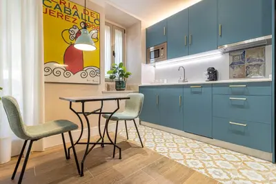 a kitchen with blue cabinets and a table and chairs at La Casa de la Plaza del Arroyo - Traditional Luxury in Jerez in Jerez de la Frontera