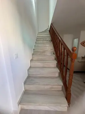 a staircase with wooden railings and white walls at Brisas de Las Piletas in Sanlúcar de Barrameda