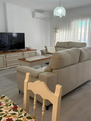 a living room with a couch and a chair at Brisas de Las Piletas in Sanlúcar de Barrameda