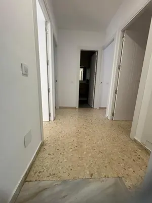 an empty room with white walls and a hallway at Brisas de Las Piletas in Sanlúcar de Barrameda