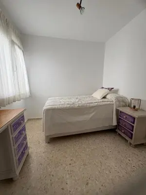 a bedroom with a bed and a dresser and a tv at Brisas de Las Piletas in Sanlúcar de Barrameda