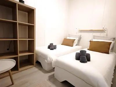 two beds in a room with a couch and a table at El Tesoro de Cadiz in Cádiz