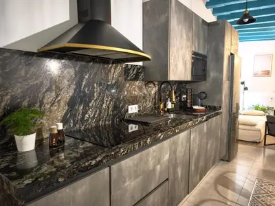 a kitchen with a granite counter top and a stove at El Tesoro de Cadiz in Cádiz