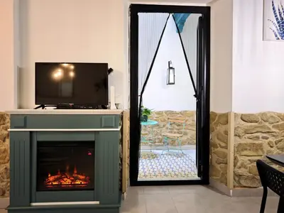 a living room with a fireplace and a tv at El Tesoro de Cadiz in Cádiz