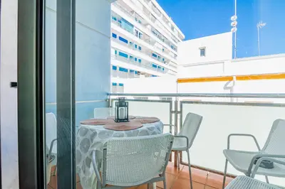 a table and chairs on the balcony of a building at Edomus Playa de la Costilla in Rota