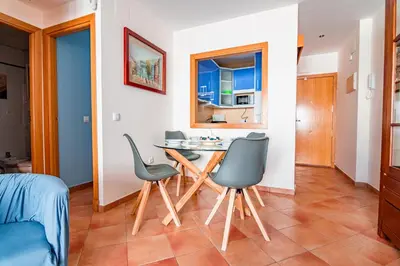 a kitchen and a dining room with a table and chairs at Edomus Playa de la Costilla in Rota