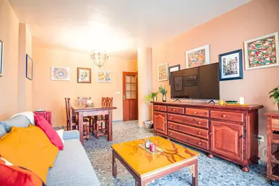 a living room with a couch and a tv and a table at Edomus Faro de Rota in Rota