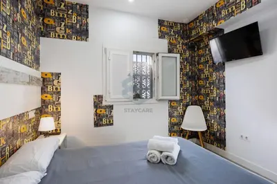 a bedroom with a bed and a tv on the wall at La Terraza by Staycare in Rota
