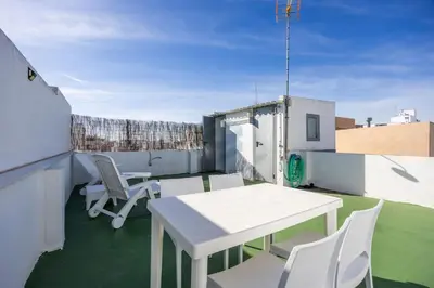 a patio with a table and chairs on a roof at La Terraza by Staycare in Rota