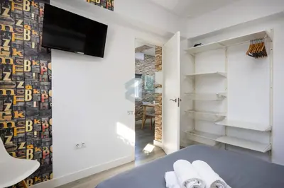 a bedroom with a bed and a tv on a wall at La Terraza by Staycare in Rota