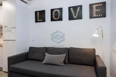 a couch in a living room with pictures on the wall at La Terraza by Staycare in Rota