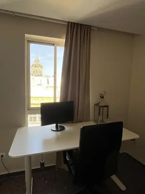 an office with a desk with a computer and a window at Brand new apartment in the heart of Jerez! in Jerez de la Frontera