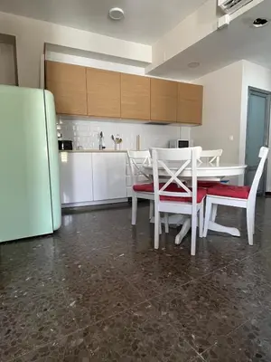 a kitchen with a table and chairs and a refrigerator at Brand new apartment in the heart of Jerez! in Jerez de la Frontera