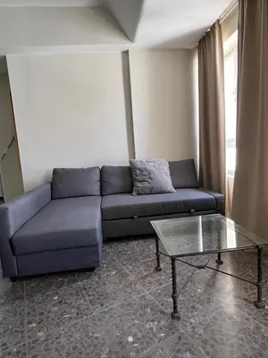 a living room with a blue couch and a glass table at Brand new apartment in the heart of Jerez! in Jerez de la Frontera