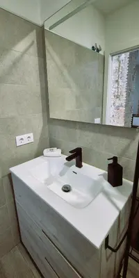 a bathroom with a white sink and a mirror at Ático de Goleta by Gades Gestión in Cádiz