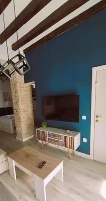 a living room with a table and a tv at Ático de Goleta by Gades Gestión in Cádiz