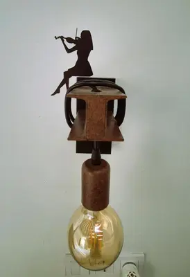 a lamp with a woman sitting on top of it at Ático de Goleta by Gades Gestión in Cádiz