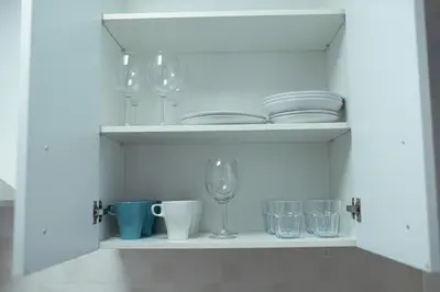 a white shelf with plates and glasses and glasses at Apartamento SOL Y DUENDE in Jerez de la Frontera