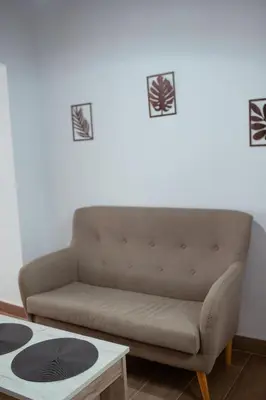 a brown couch in a living room with a table at Apartamento SOL Y DUENDE in Jerez de la Frontera