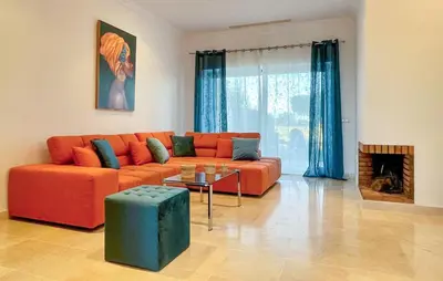 a living room with an orange couch and a table at 2 Bedroom Nice Home In Arcos De La Frontera in Arcos de la Frontera