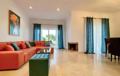 a living room with a orange couch and blue curtains at 2 Bedroom Nice Home In Arcos De La Frontera in Arcos de la Frontera