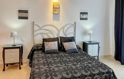 a bedroom with a bed with two night stands and two lamps at 2 Bedroom Nice Home In Arcos De La Frontera in Arcos de la Frontera