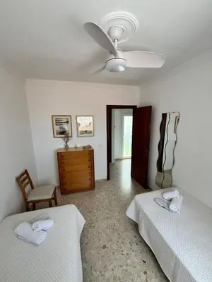a bedroom with two beds and a ceiling fan at Tu ático ideal Terraza, Centro y Playa a pie in Sanlúcar de Barrameda