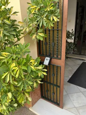 a door with a sign on it next to some plants at Tu ático ideal Terraza, Centro y Playa a pie in Sanlúcar de Barrameda