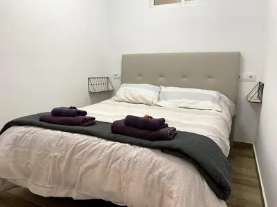 a bed with two purple towels on top of it at Fabuloso Apartamento centrico San Miguel WIFI in Jerez de la Frontera