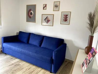 a blue couch in a living room with pictures on the wall at Fabuloso Apartamento centrico San Miguel WIFI in Jerez de la Frontera