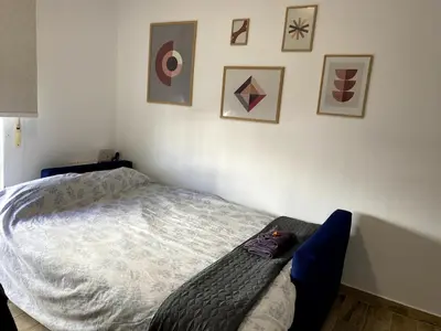 a bedroom with a bed and pictures on the wall at Fabuloso Apartamento centrico San Miguel WIFI in Jerez de la Frontera