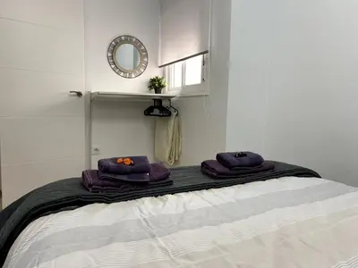 a bedroom with a bed with purple towels on it at Fabuloso Apartamento centrico San Miguel WIFI in Jerez de la Frontera