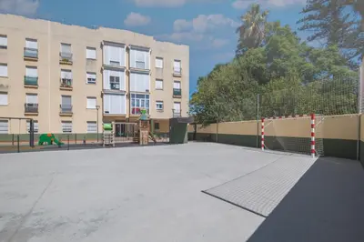 an empty playground in front of a building at Acogedor apartamento con parque infantil in Jerez de la Frontera