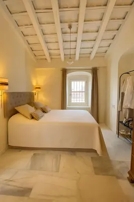 a bedroom with a large bed and a window at La Bohéme in Jerez de la Frontera