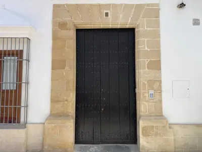 a black door on the side of a building at La Bohéme in Jerez de la Frontera