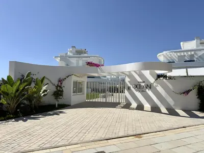 a white house with a gate and a patio at Amenábar Ocean Suites by Staycare in Chipiona