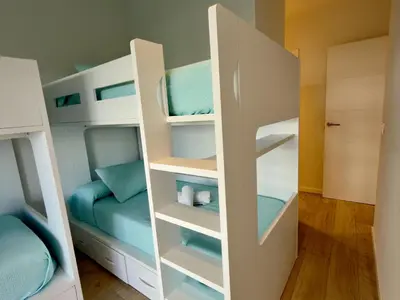 a room with bunk beds in a room with a bed at Amenábar Ocean Suites by Staycare in Chipiona