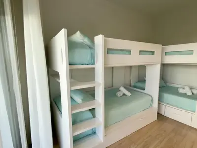 a bunk bed room with two bunk beds at Amenábar Ocean Suites by Staycare in Chipiona