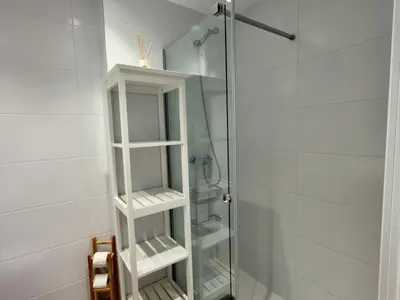 a bathroom with a shower with a glass door at Amenábar Ocean Suites by Staycare in Chipiona