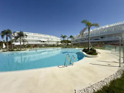a swimming pool in front of a large building at Amenábar Ocean Suites by Staycare in Chipiona