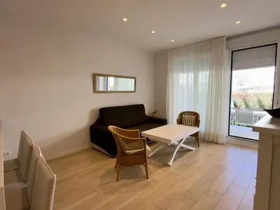 a living room with a couch and a table and chairs at Amenábar Ocean Suites by Staycare in Chipiona