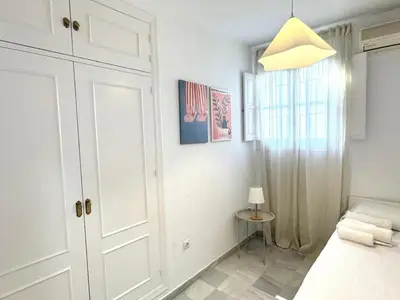 a white bedroom with a bed and a window at Sibs Sanlucar Bajamar - Bright & Central in Sanlúcar de Barrameda