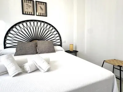a white bedroom with a large white bed with two pillows at Sibs Sanlucar Bajamar - Bright & Central in Sanlúcar de Barrameda