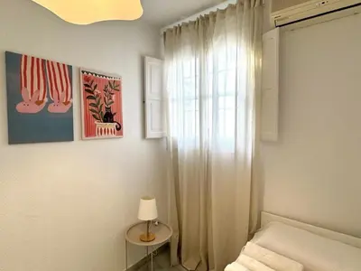 a bedroom with a bed and a window and a lamp at Sibs Sanlucar Bajamar - Bright & Central in Sanlúcar de Barrameda