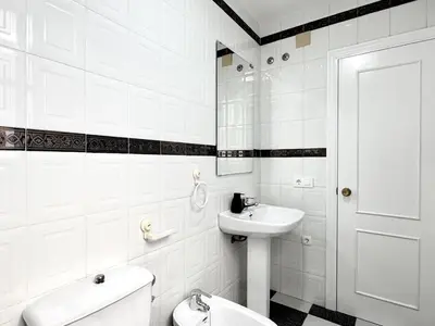 a white bathroom with a toilet and a sink at Sibs Sanlucar Bajamar - Bright & Central in Sanlúcar de Barrameda