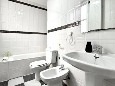 a white bathroom with a toilet and a sink at Sibs Sanlucar Bajamar - Bright & Central in Sanlúcar de Barrameda